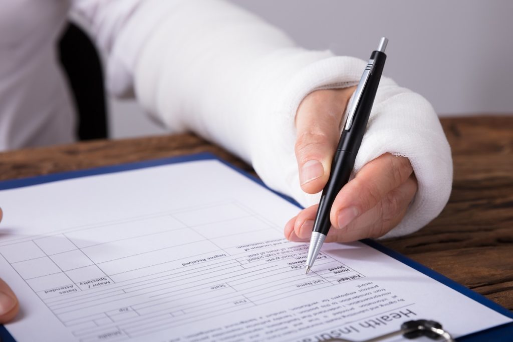 man with broken arm signing paper