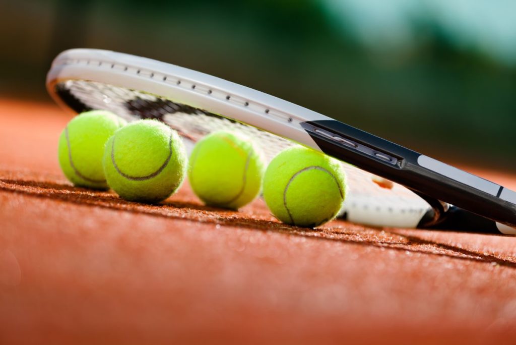 tennis racket and tennis balls on the ground
