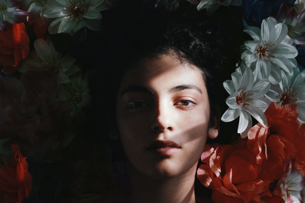 woman's face on a bed of flowers