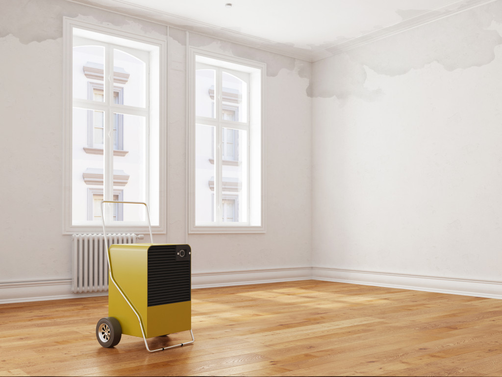 An image of a dehumidifier inside a water-damaged room