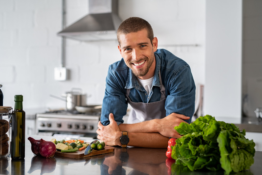 man smiling while cooking in the kitchen