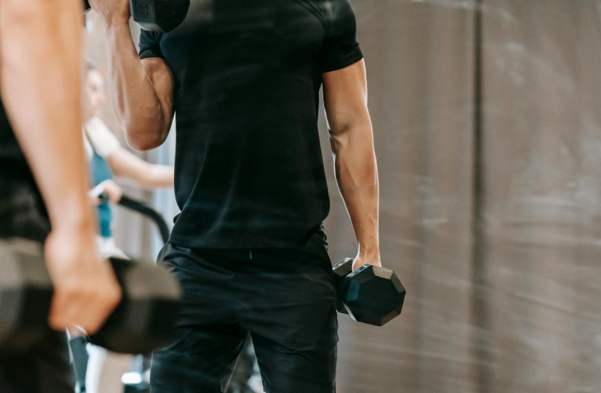 man lifting dumbbells in the gym